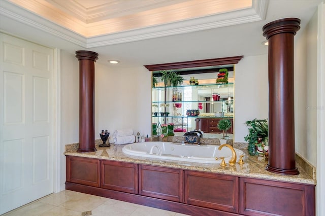 bathroom featuring a raised ceiling, tile floors, ornamental molding, a bathing tub, and ornate columns