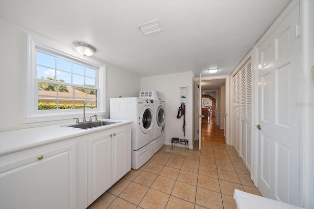 laundry room with independent washer and dryer, light hardwood / wood-style floors, cabinets, and sink