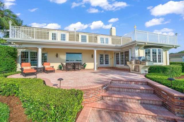 rear view of house featuring a patio, french doors, and a balcony