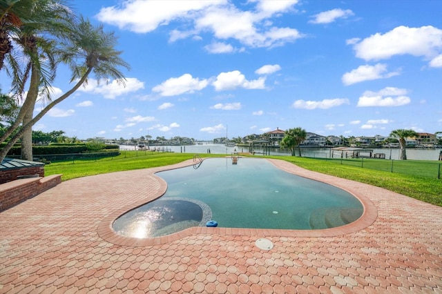 view of pool featuring a water view, a patio, and a lawn