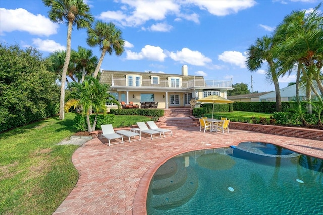 view of swimming pool featuring a yard, an in ground hot tub, and a patio area