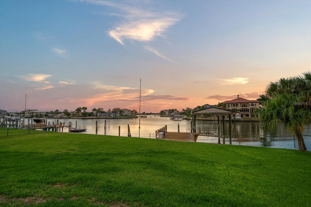 dock area featuring a water view and a lawn