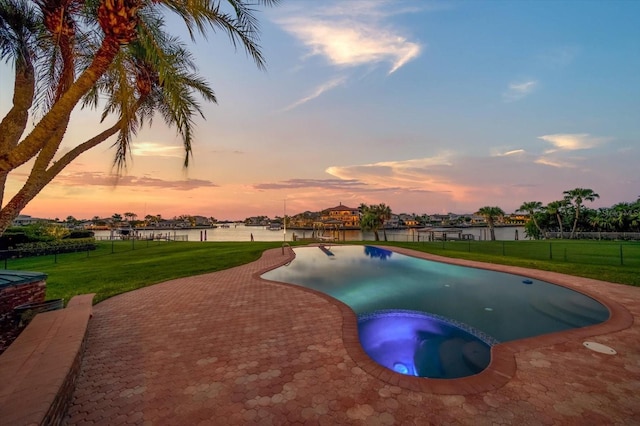 pool at dusk with a gazebo, a yard, an in ground hot tub, and a water view