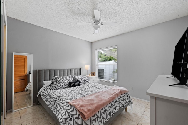 tiled bedroom with a textured ceiling and ceiling fan