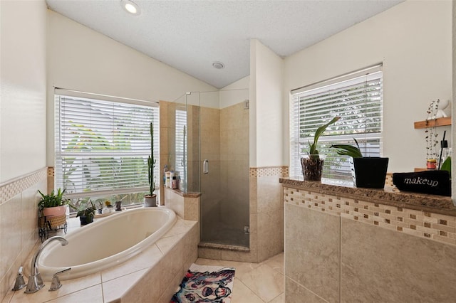 bathroom featuring tile patterned floors, lofted ceiling, a textured ceiling, and plus walk in shower