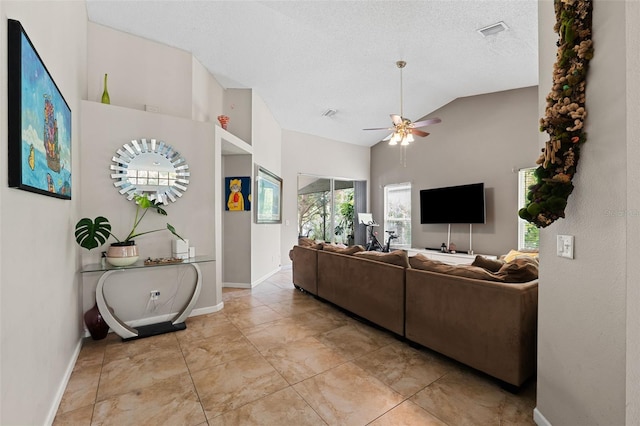 living room featuring vaulted ceiling, ceiling fan, and a textured ceiling