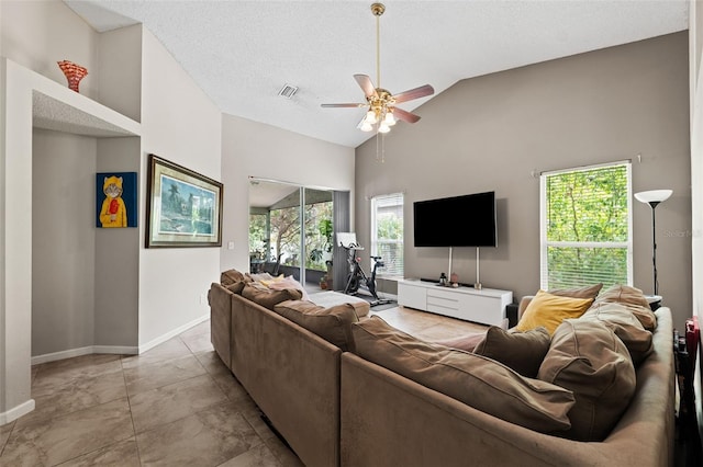 living room with a textured ceiling, ceiling fan, and lofted ceiling