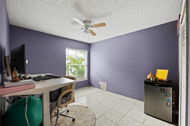 office area featuring a textured ceiling, ceiling fan, and light tile patterned flooring