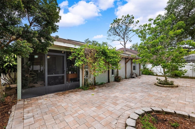 back of property with a patio area and a sunroom