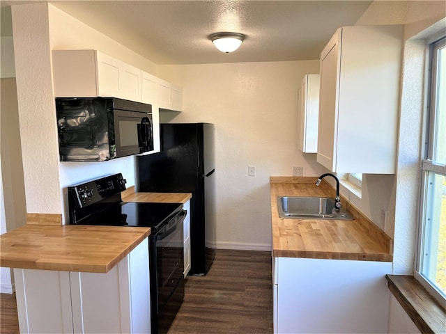 kitchen with dark hardwood / wood-style floors, black appliances, wooden counters, sink, and white cabinets