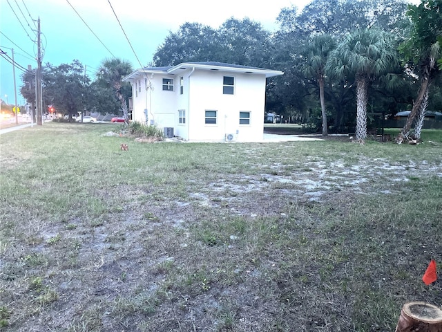 rear view of house featuring a lawn and central air condition unit