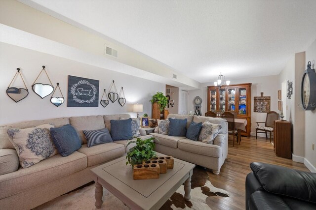 living room with hardwood / wood-style floors and a notable chandelier