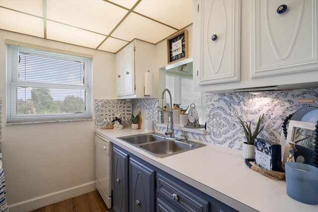 kitchen featuring dark hardwood / wood-style flooring, blue cabinetry, white cabinets, white dishwasher, and sink