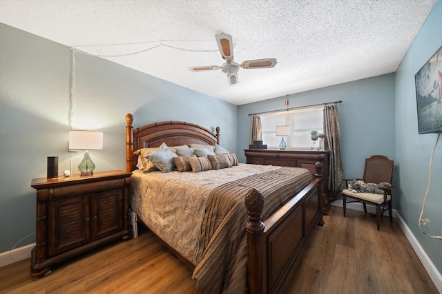 bedroom featuring a textured ceiling, wood finished floors, a ceiling fan, and baseboards