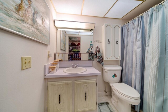 bathroom with tile patterned flooring, curtained shower, vanity, and toilet