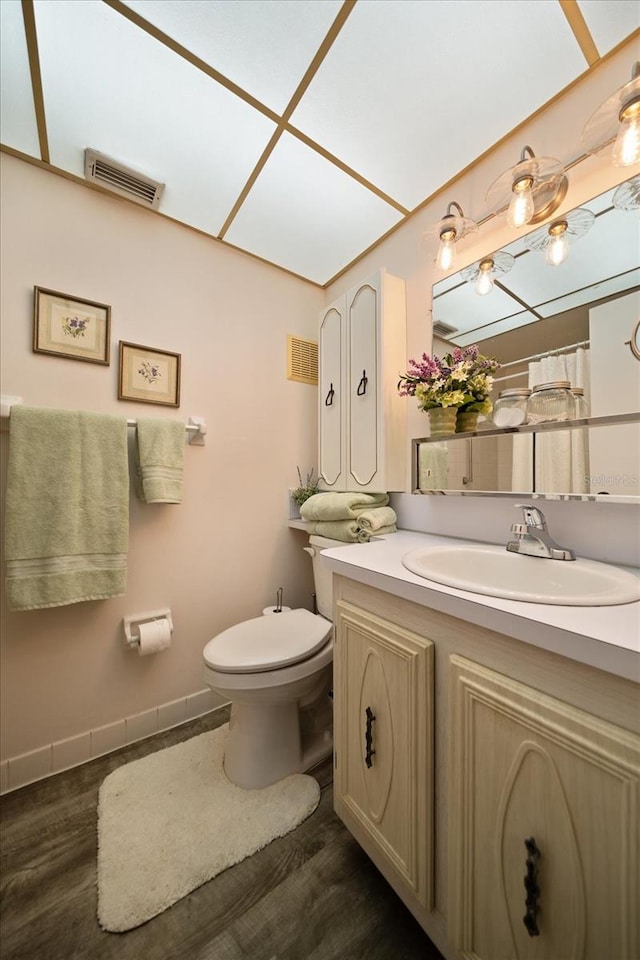 bathroom featuring toilet, hardwood / wood-style floors, and vanity