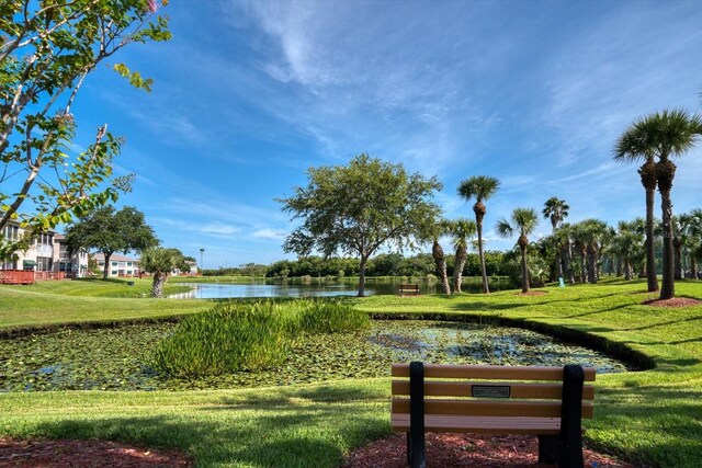 view of community with a lawn and a water view