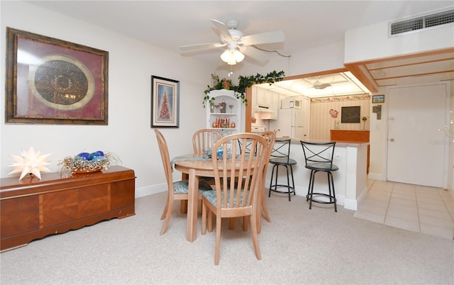 dining space with light tile patterned flooring, light colored carpet, a ceiling fan, baseboards, and visible vents