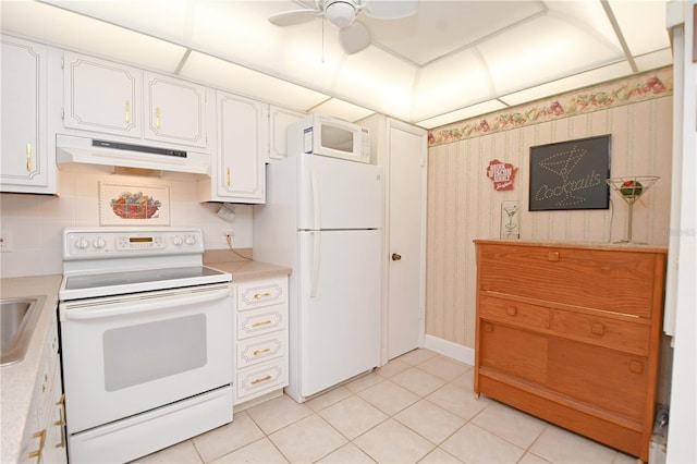 kitchen with white appliances, light countertops, under cabinet range hood, and white cabinetry