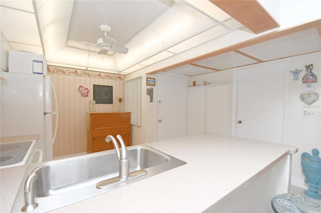 kitchen featuring white refrigerator, stove, sink, and ceiling fan