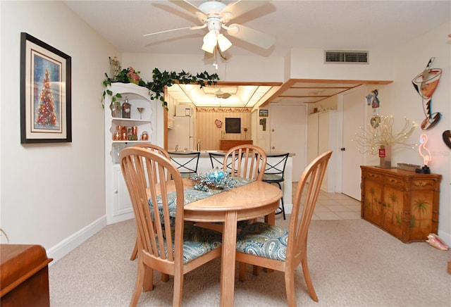 dining area with light colored carpet, visible vents, and ceiling fan