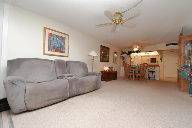 living room with carpet, visible vents, and ceiling fan