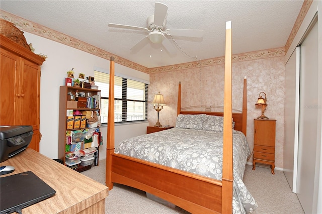 bedroom with a textured ceiling, ceiling fan, and light colored carpet