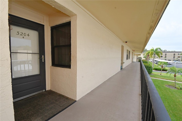 entrance to property with a balcony and a yard