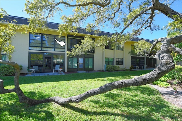 back of property featuring a yard and a patio