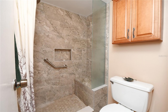 bathroom featuring a tile shower and toilet