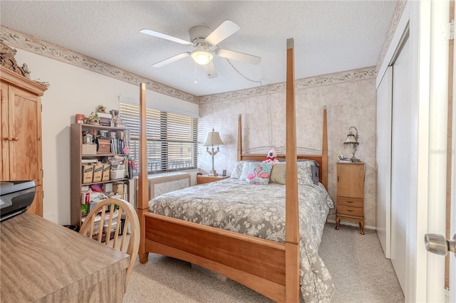 bedroom with light carpet, a ceiling fan, and a textured ceiling