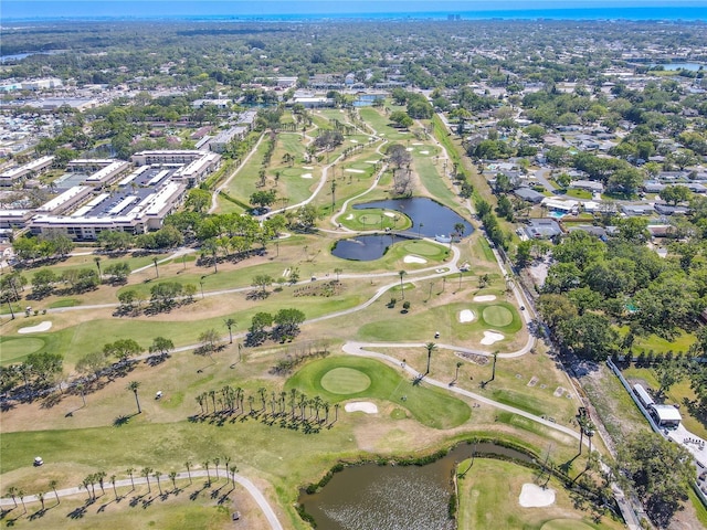 drone / aerial view featuring golf course view and a water view