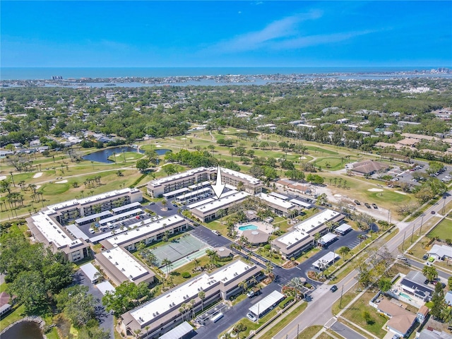 drone / aerial view with view of golf course and a water view
