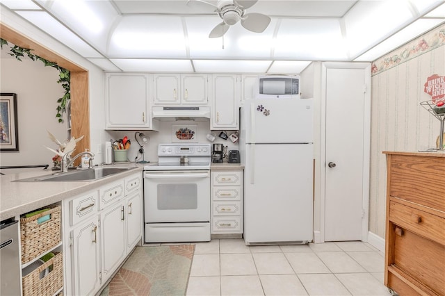 kitchen with white cabinetry, a sink, under cabinet range hood, and white appliances