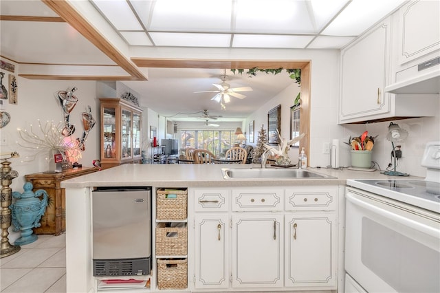 kitchen featuring a peninsula, a ceiling fan, electric stove, a sink, and fridge