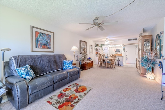 carpeted living room featuring a ceiling fan, a textured ceiling, and visible vents