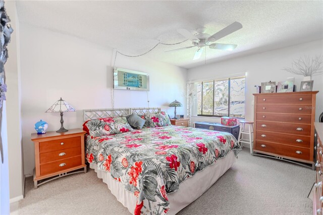 bedroom featuring a ceiling fan, carpet, and a textured ceiling