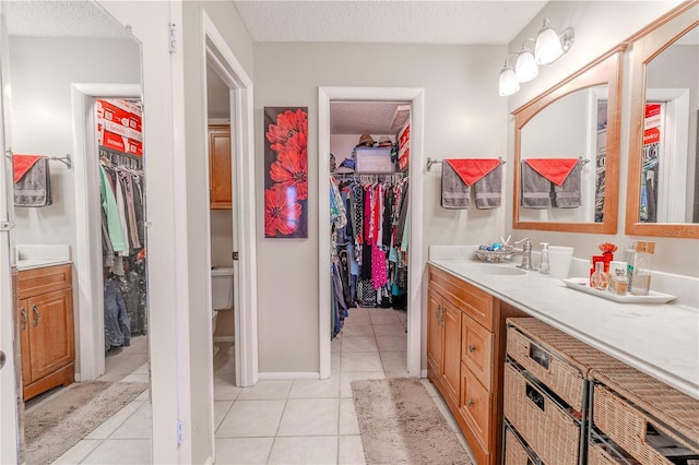 bathroom with tile patterned floors, vanity, and a textured ceiling