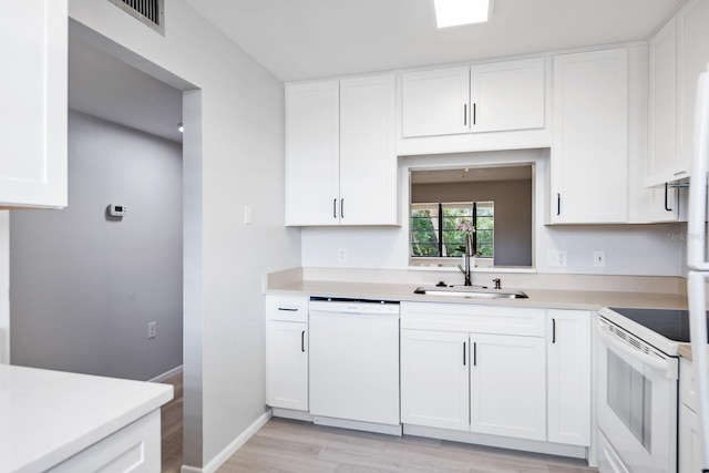 kitchen with sink, white cabinets, white appliances, and light hardwood / wood-style flooring