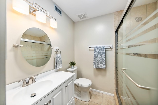 bathroom with tile patterned flooring, vanity, a shower with door, and toilet