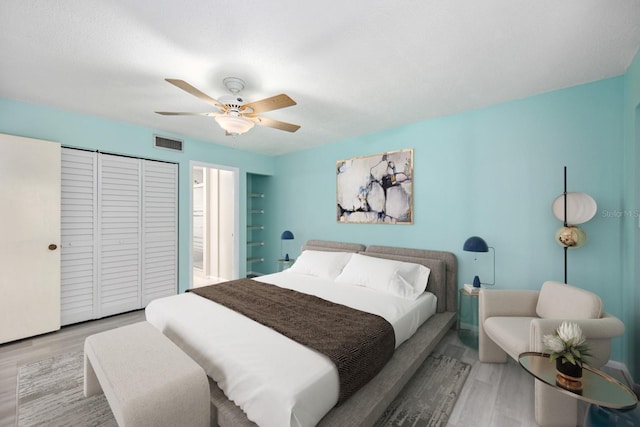 bedroom with light hardwood / wood-style floors, a closet, and ceiling fan