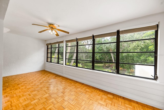 empty room with light parquet floors and ceiling fan