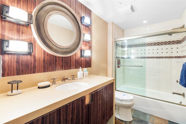 full bathroom with vanity, shower / bath combination with glass door, and toilet