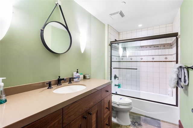 full bathroom featuring toilet, vanity, and bath / shower combo with glass door