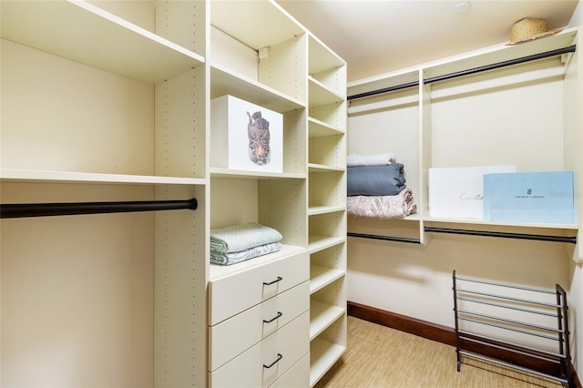 walk in closet with light hardwood / wood-style flooring