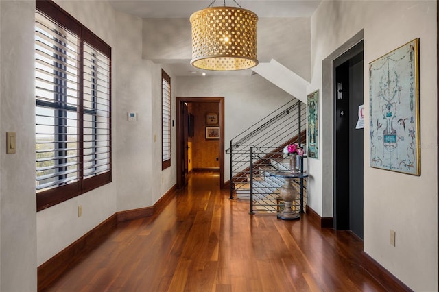 foyer featuring dark wood-type flooring and an inviting chandelier