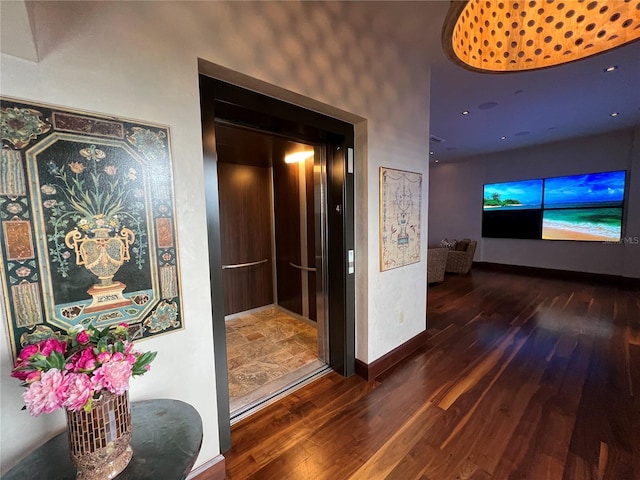 hallway with elevator and dark hardwood / wood-style floors