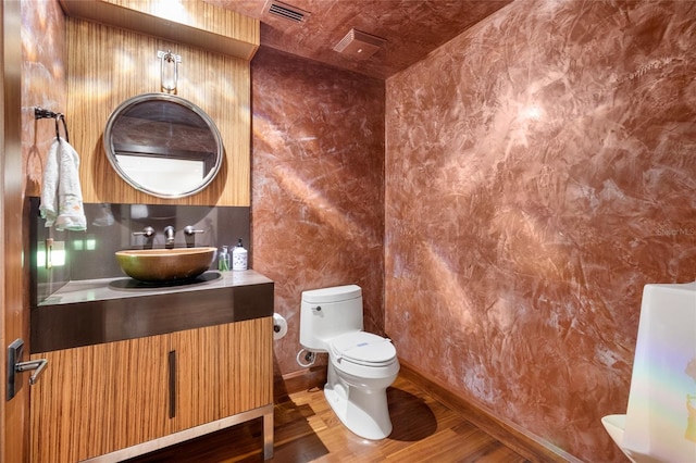 bathroom with tasteful backsplash, vanity, hardwood / wood-style floors, and toilet