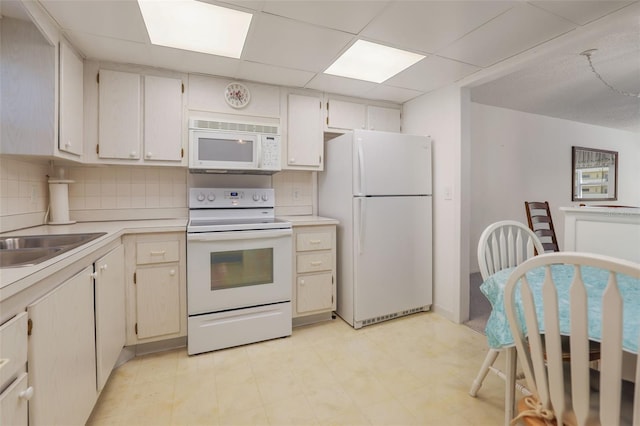 kitchen with white appliances, tasteful backsplash, and light tile flooring