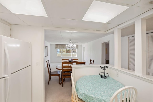 carpeted dining area featuring a paneled ceiling and ceiling fan